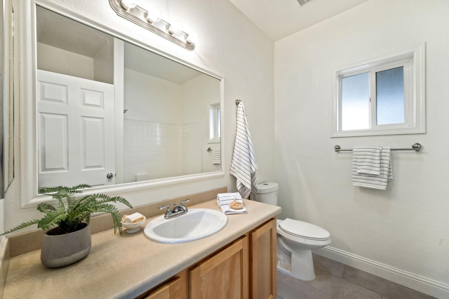 6130 Monterey Road, Unit 189 San Jose, CA 95138 - Photo 22 of 42 a bathroom with a granite countertop sink a toilet and a mirror