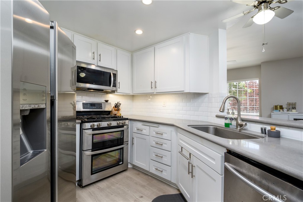 628 Daisy Avenue, Unit 222 Long Beach, CA 90802 - Photo 6 of 25 a kitchen with a sink stainless steel appliances and white cabinets