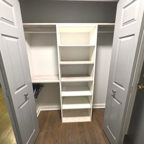 a view of walk in closet with empty racks