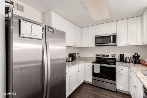 a kitchen with a refrigerator stove and white cabinets