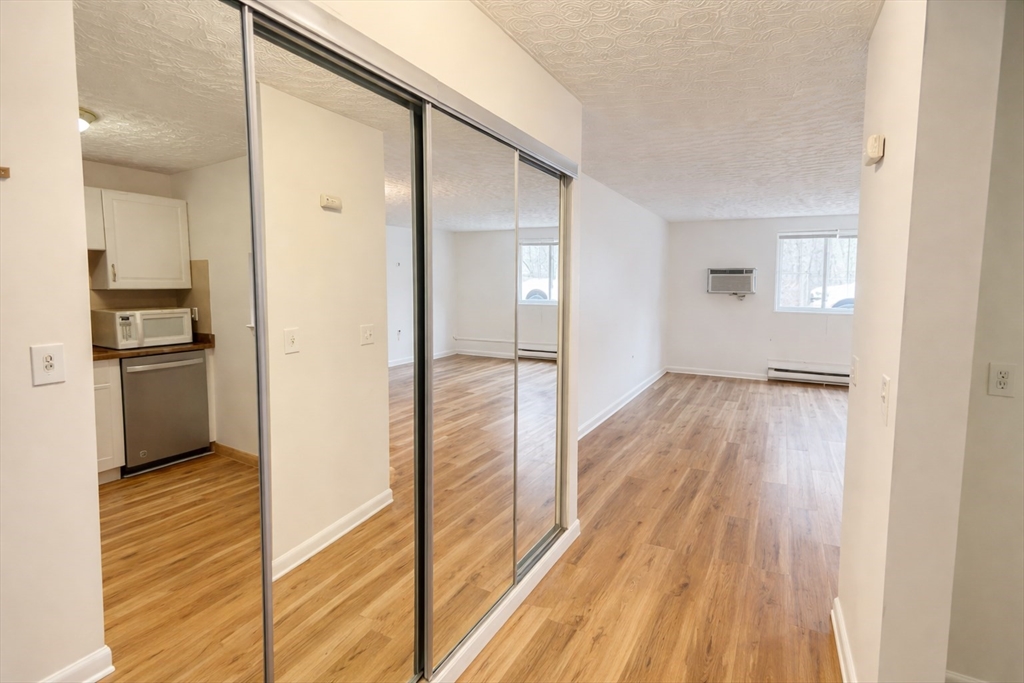 15 Weld Street, Unit 18 Framingham, MA 01702 - Photo 2 of 18 a view of a hallway with wooden floor and a living room