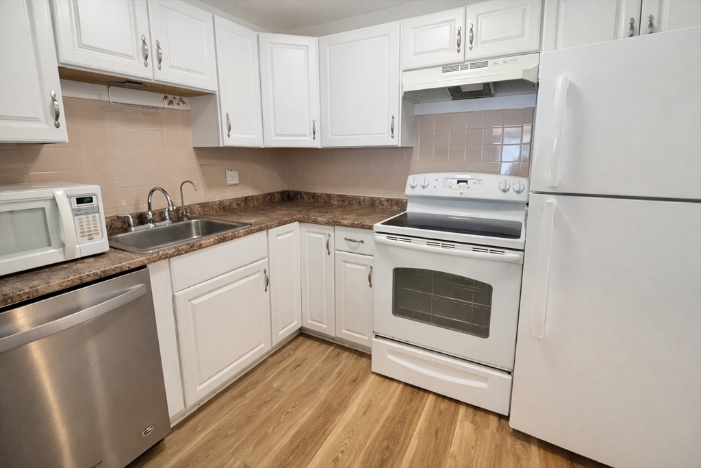 15 Weld Street, Unit 18 Framingham, MA 01702 - Photo 4 of 18 a kitchen with cabinets stainless steel appliances and wooden floor