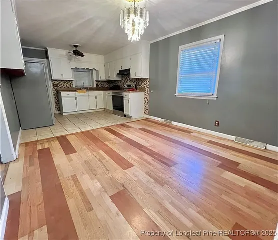 a view of a kitchen with a sink dishwasher a refrigerator and wooden floor