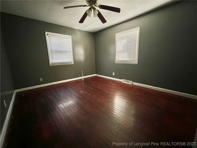 a view of room with window ceiling fan and hardwood floor