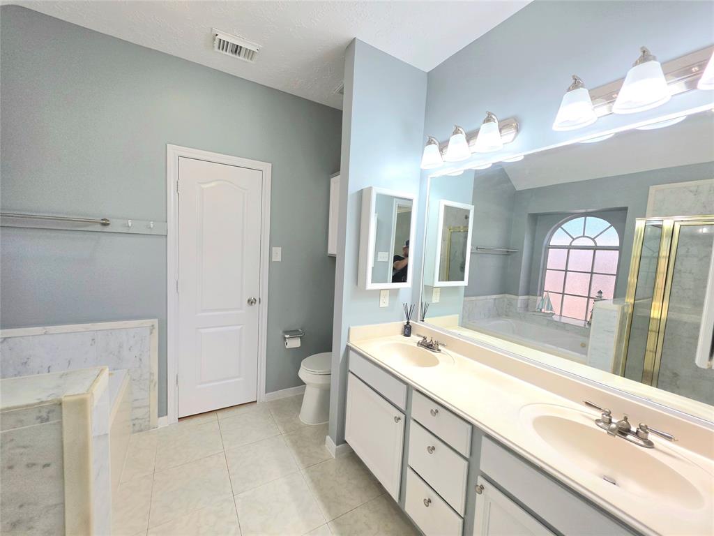 13618 Sablegrove Lane Houston, TX 77014 - Photo 19 of 30 a spacious bathroom with a tub sink and mirror