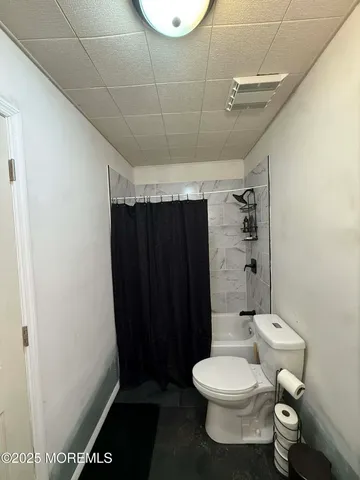 a bathroom with a toilet and a shower