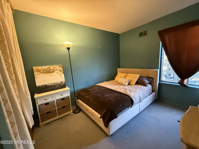 a bedroom with a bed and a mirror on the wall