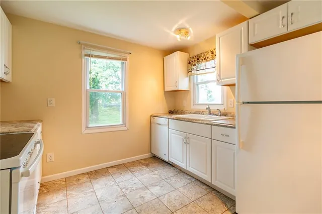 a kitchen with a refrigerator sink stove and cabinets
