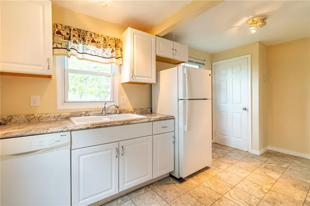 a kitchen with a refrigerator sink and cabinets