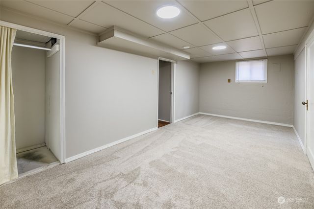 a view of a patio with table and chairs under an umbrella with large trees
