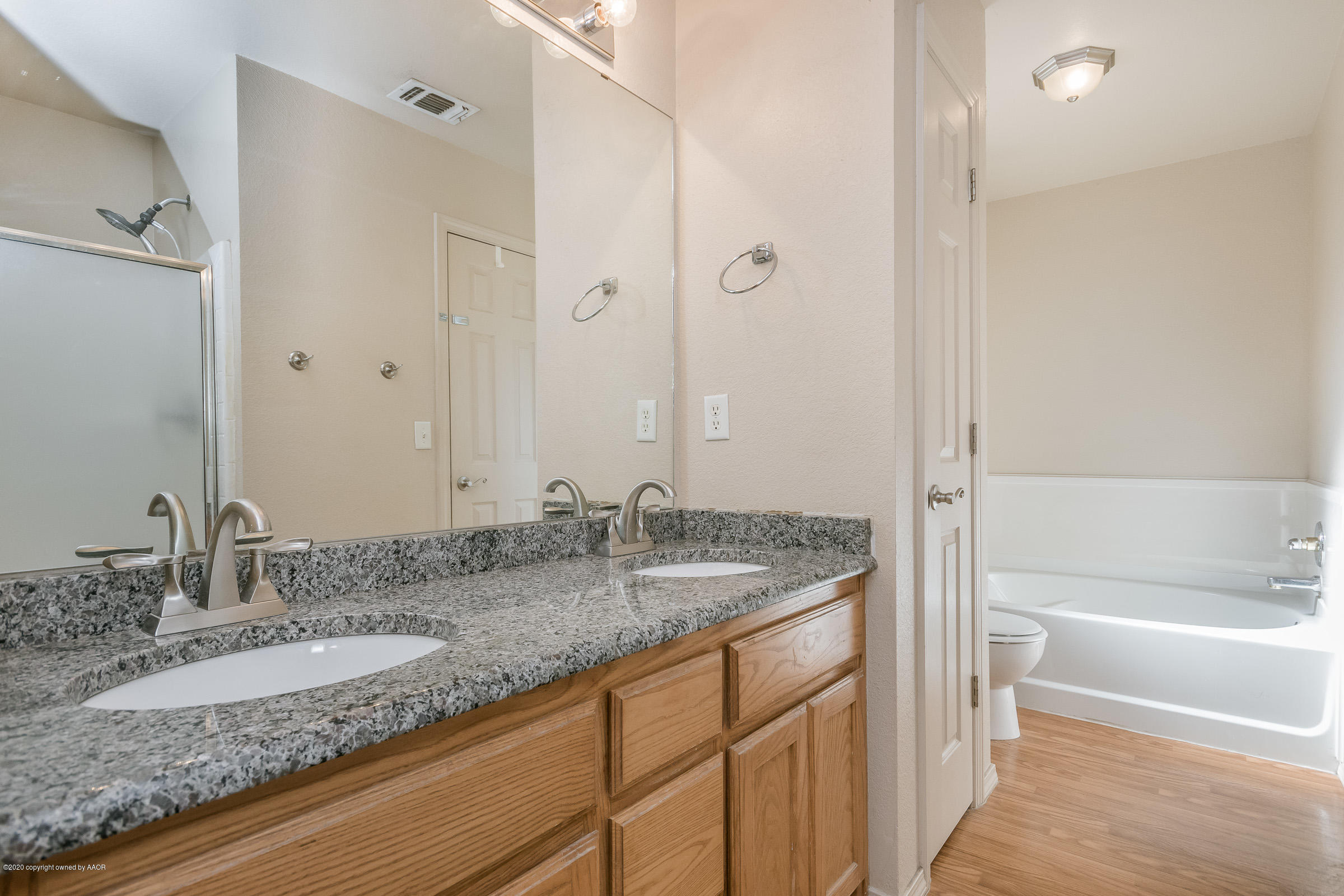 4812 Capulin Lane Amarillo, TX 79110 - Photo 11 of 20 a bathroom with a granite countertop sink and a mirror a bathtub
