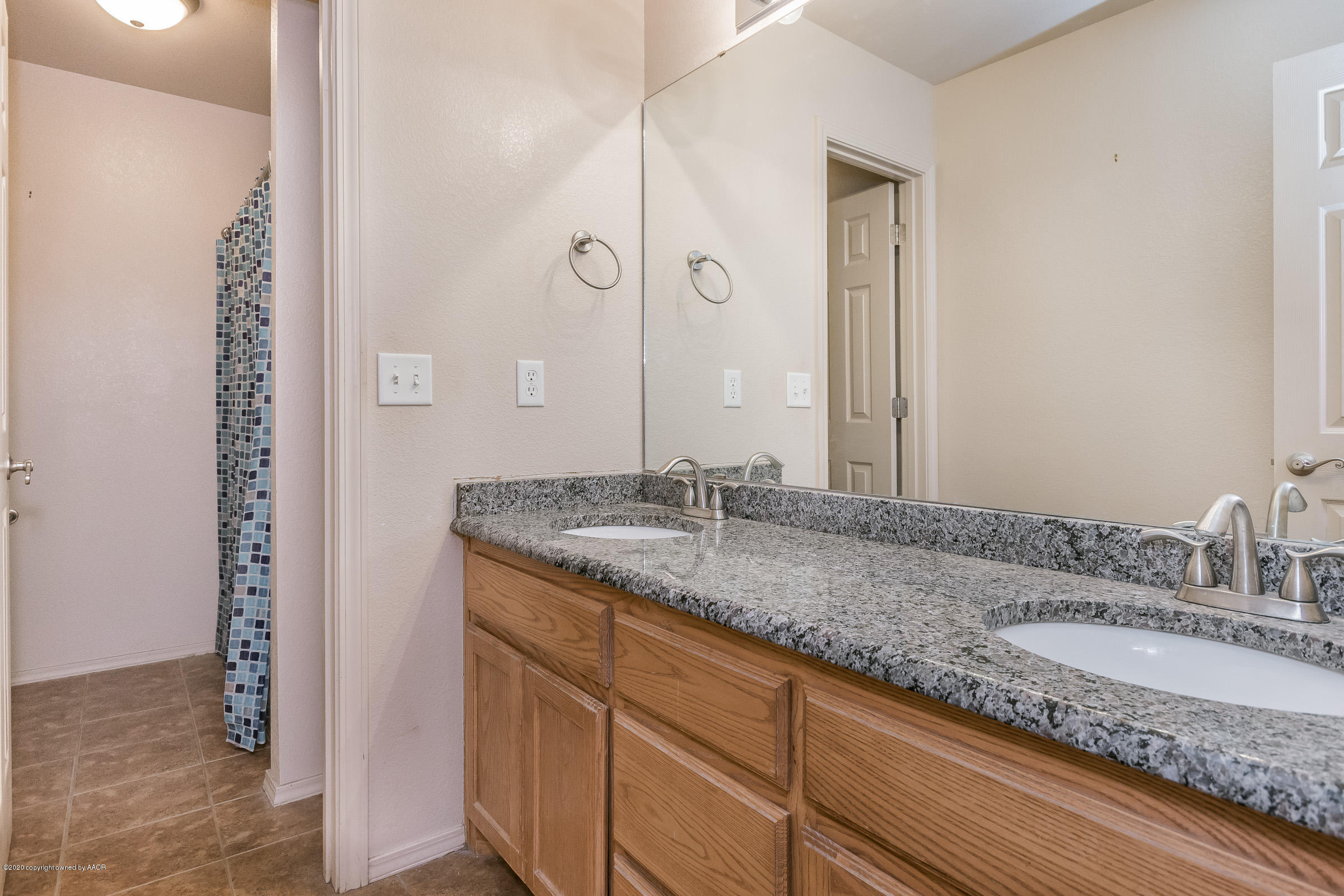 4812 Capulin Lane Amarillo, TX 79110 - Photo 15 of 20 a bathroom with a granite countertop sink and a mirror