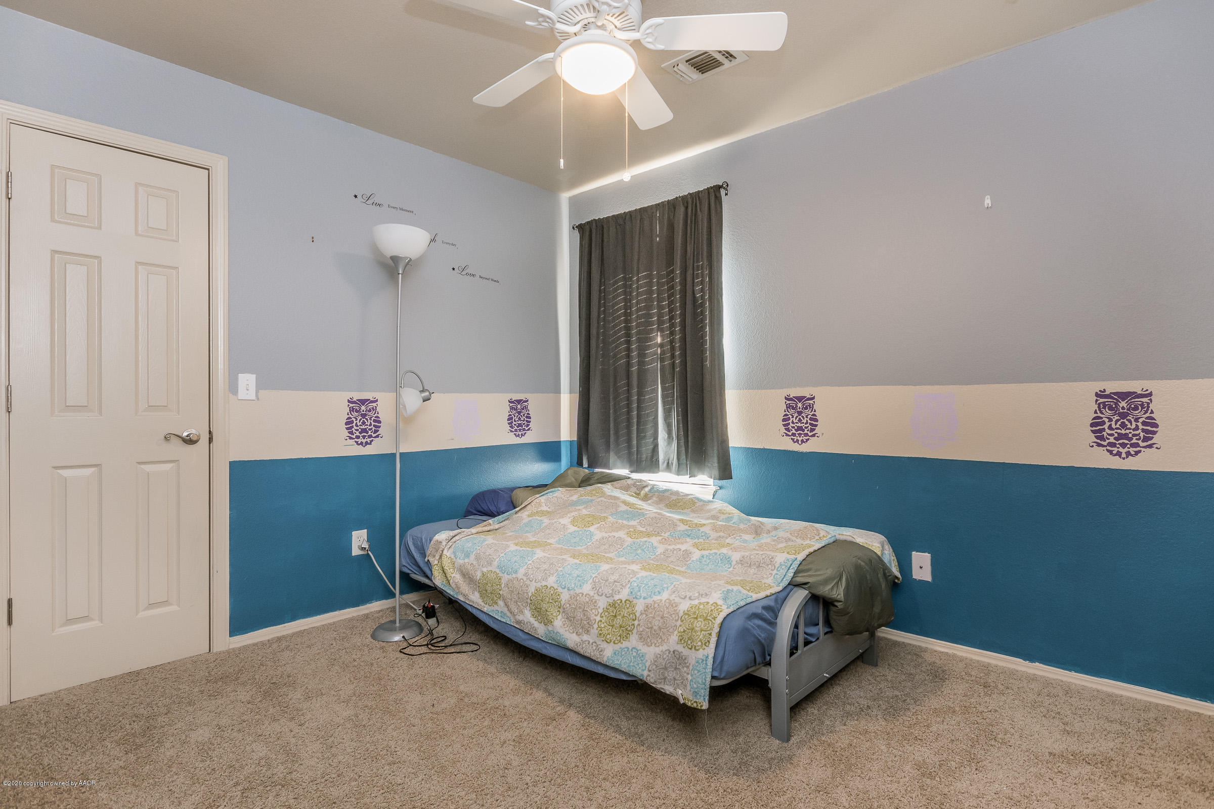 4812 Capulin Lane Amarillo, TX 79110 - Photo 17 of 20 a bedroom with a bed and a chandelier