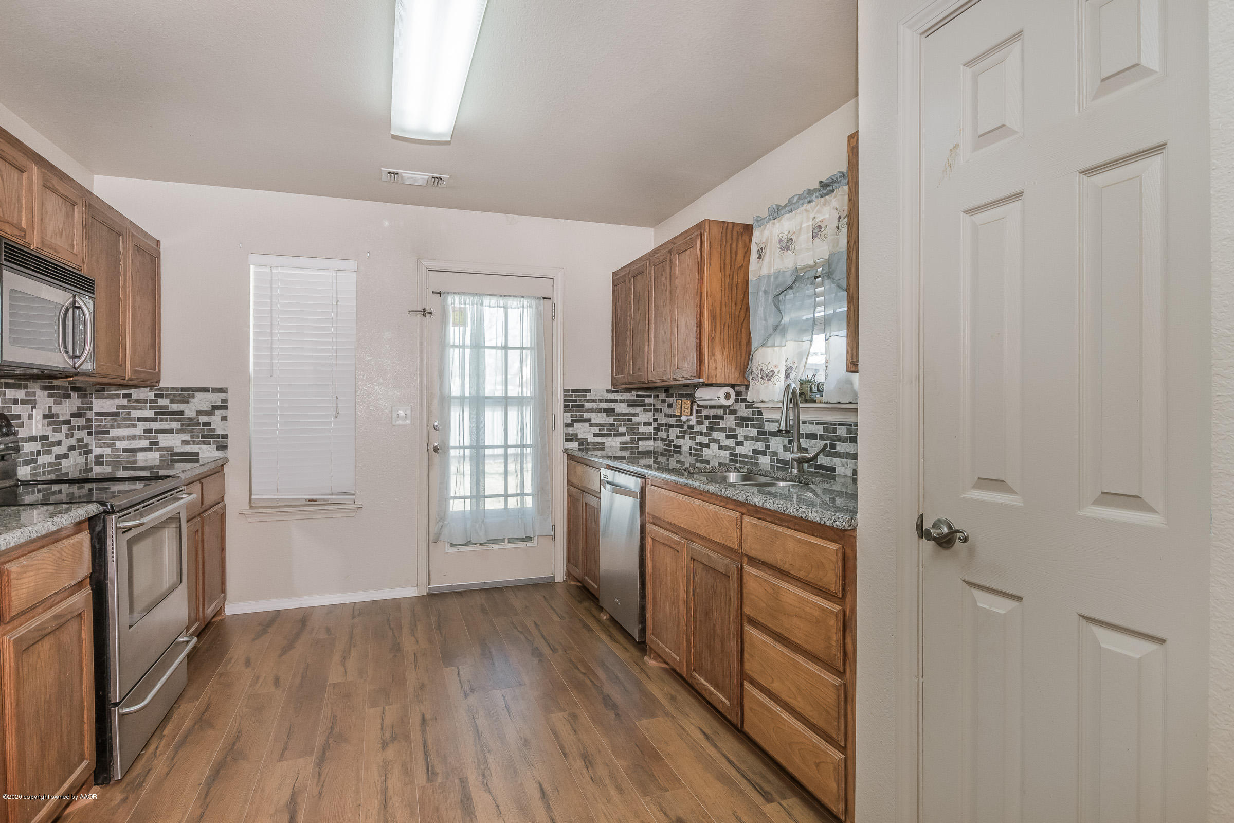 4812 Capulin Lane Amarillo, TX 79110 - Photo 5 of 20 a kitchen with stainless steel appliances a stove and white cabinets