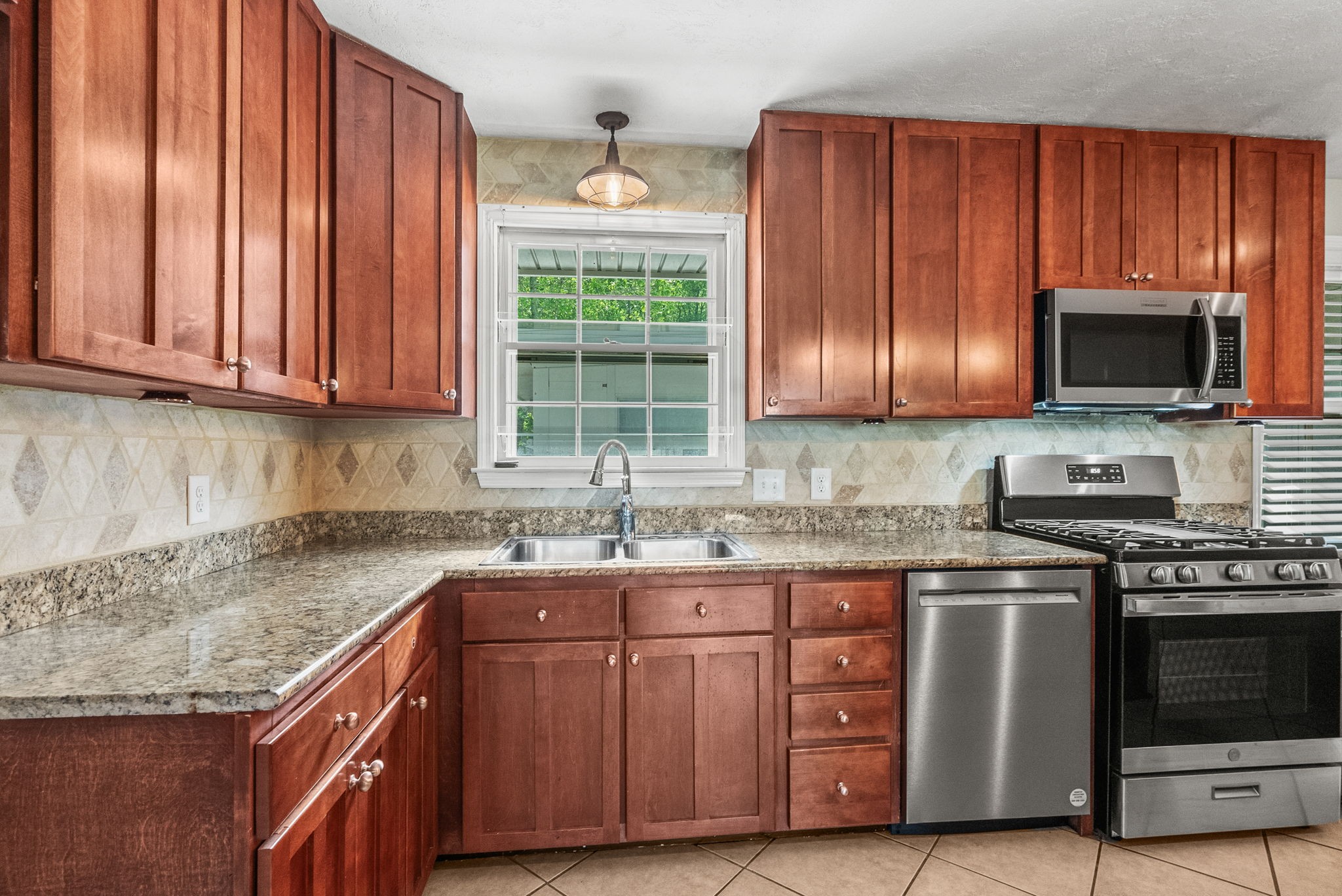 4120 Sycamore Road Greenbrier, TN 37073 - Photo 11 of 31 a kitchen with granite countertop stainless steel appliances a stove a sink and a microwave