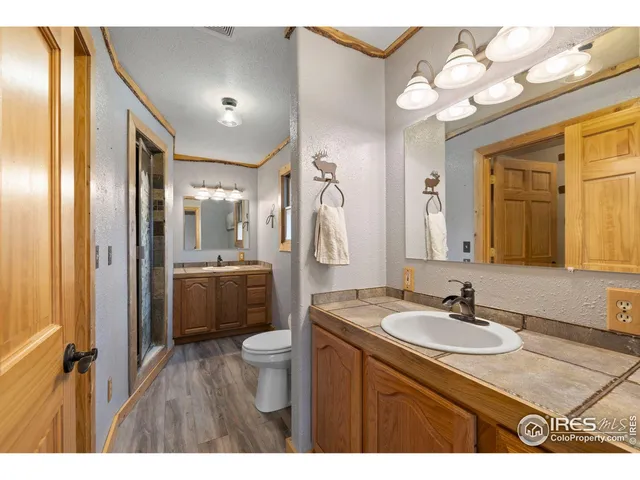 a bathroom with a sink vanity granite tub and a mirror