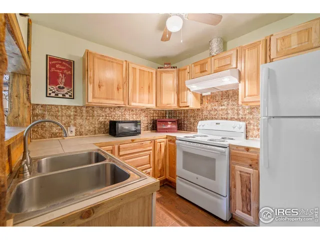 a kitchen with a refrigerator sink and white cabinets