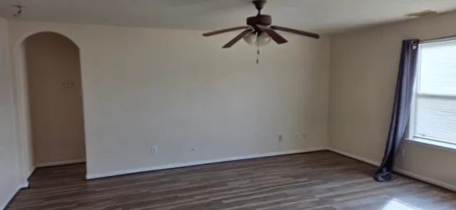 a view of a room with wooden floor and ceiling fan