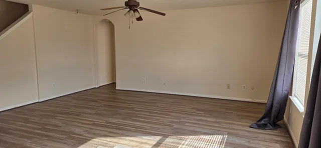 a view of a room with wooden floor and a window