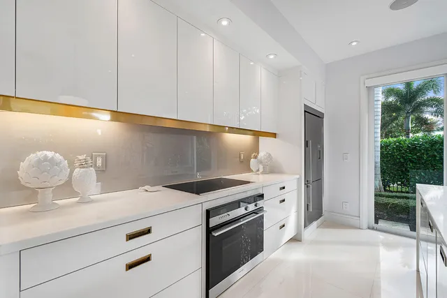 a kitchen with refrigerator and chairs