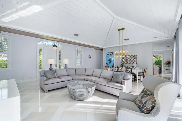 a view of a dining room with furniture a chandelier and window