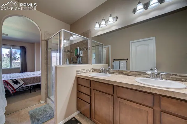 a en suite bathroom with a double vanity sink and a mirror