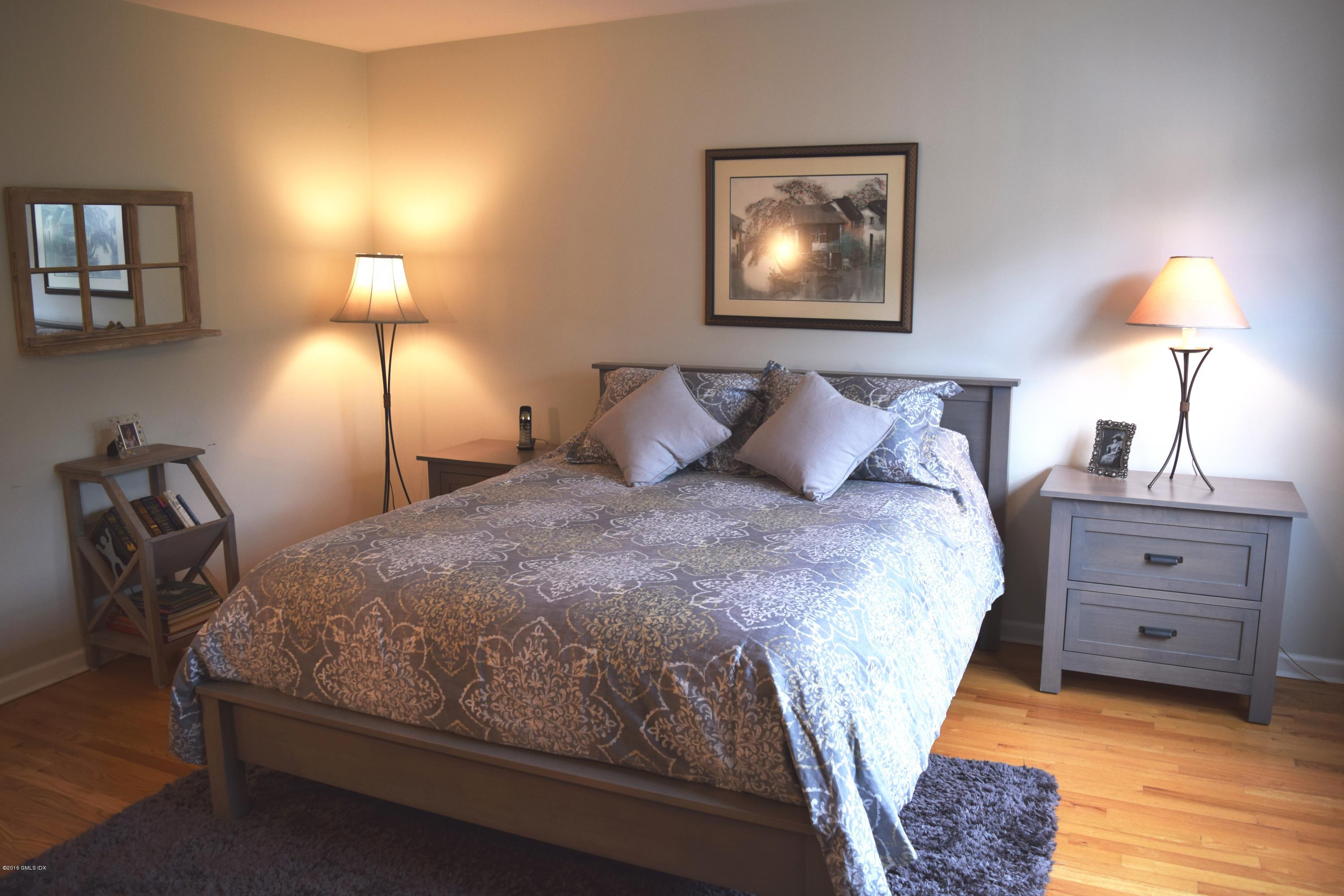 28 Home Place, Unit B2 Greenwich, CT 06830 - Photo 11 of 15 a bedroom with a bed and a lamp with the wooden floor