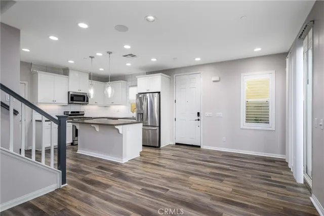 a kitchen with stainless steel appliances granite countertop a refrigerator and a stove top oven