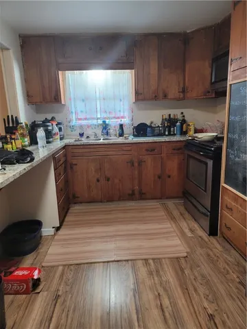 a kitchen with wooden floors and wooden cabinets