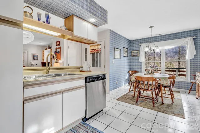a open kitchen with stainless steel appliances granite countertop a stove and a dining table chair