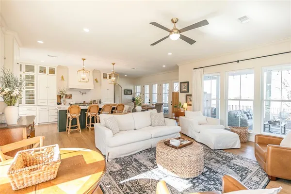 a living room with furniture ceiling fan and a large window