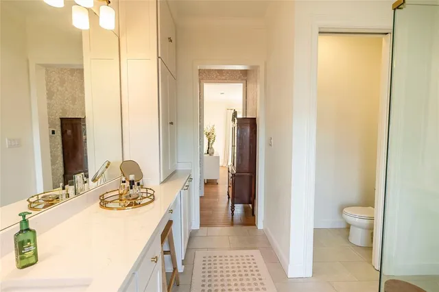 a bathroom with a granite countertop sink a toilet and shower