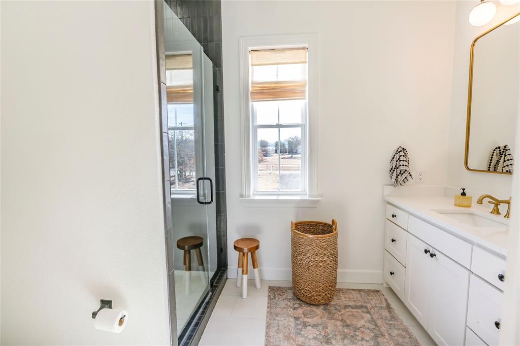 1061 Tradewinds Road Nocona, TX 76255 - Photo 20 of 40 a bathroom with a sink a toilet and a mirror