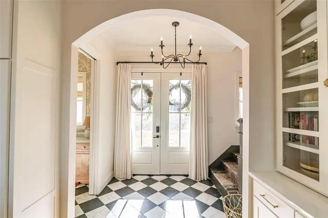 a view of a hallway with windows and chandelier