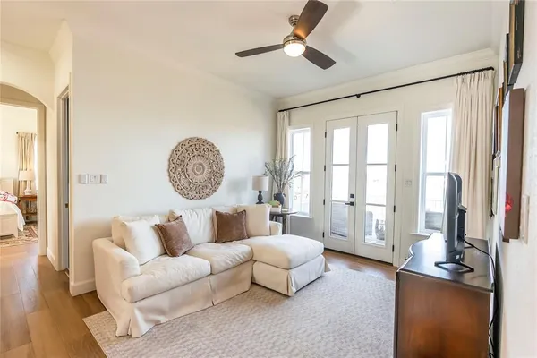 a living room with furniture a large window and a chandelier