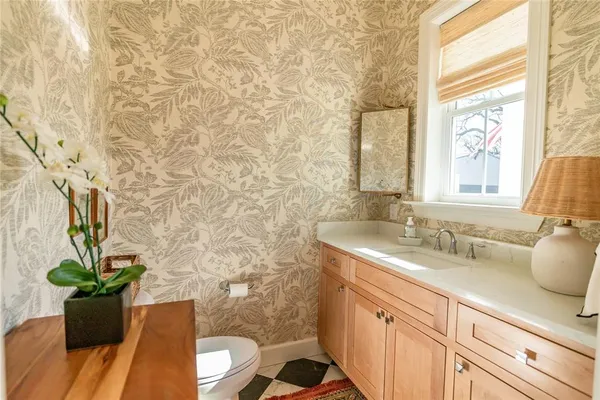 a bathroom with a granite countertop sink a mirror and a shower