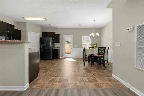 a kitchen with stainless steel appliances kitchen island granite countertop a refrigerator and a stove top oven