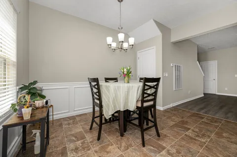 a view of a dining room with furniture and a chandelier