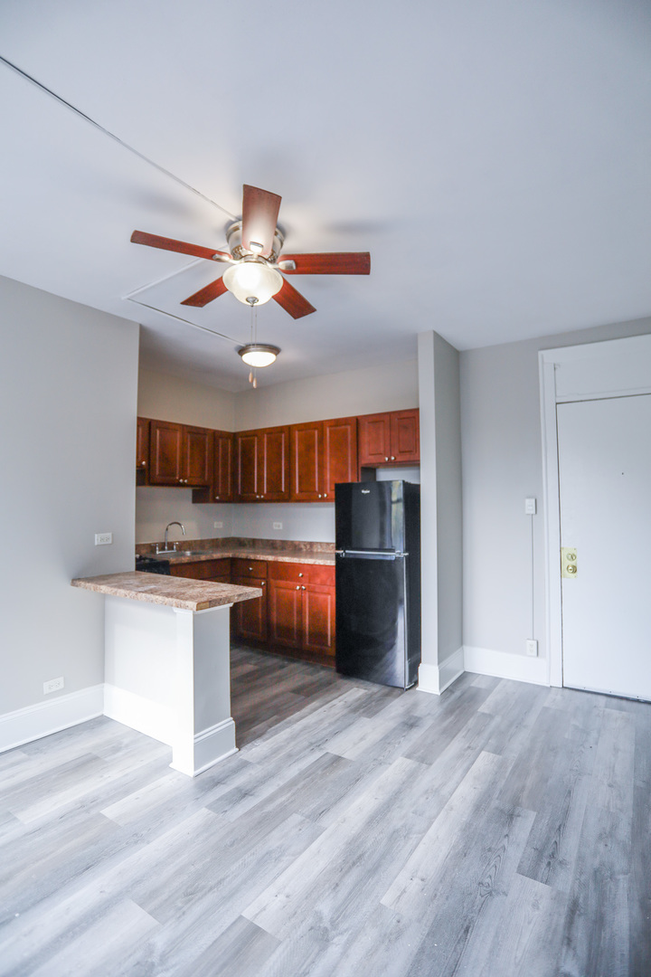5326 South Cornell Avenue, Unit 207 Chicago, IL 60615 - Photo 3 of 12 a kitchen with stainless steel appliances granite countertop a refrigerator a stove and a wooden floors