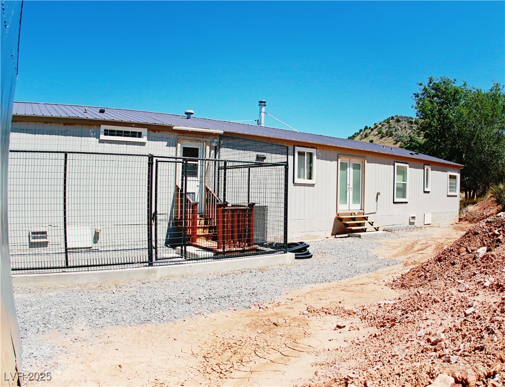 437 Pioche Street Pioche, NV 89043 - Photo 6 of 48 Rear view of house with entry steps, crawl space, and a metal roof