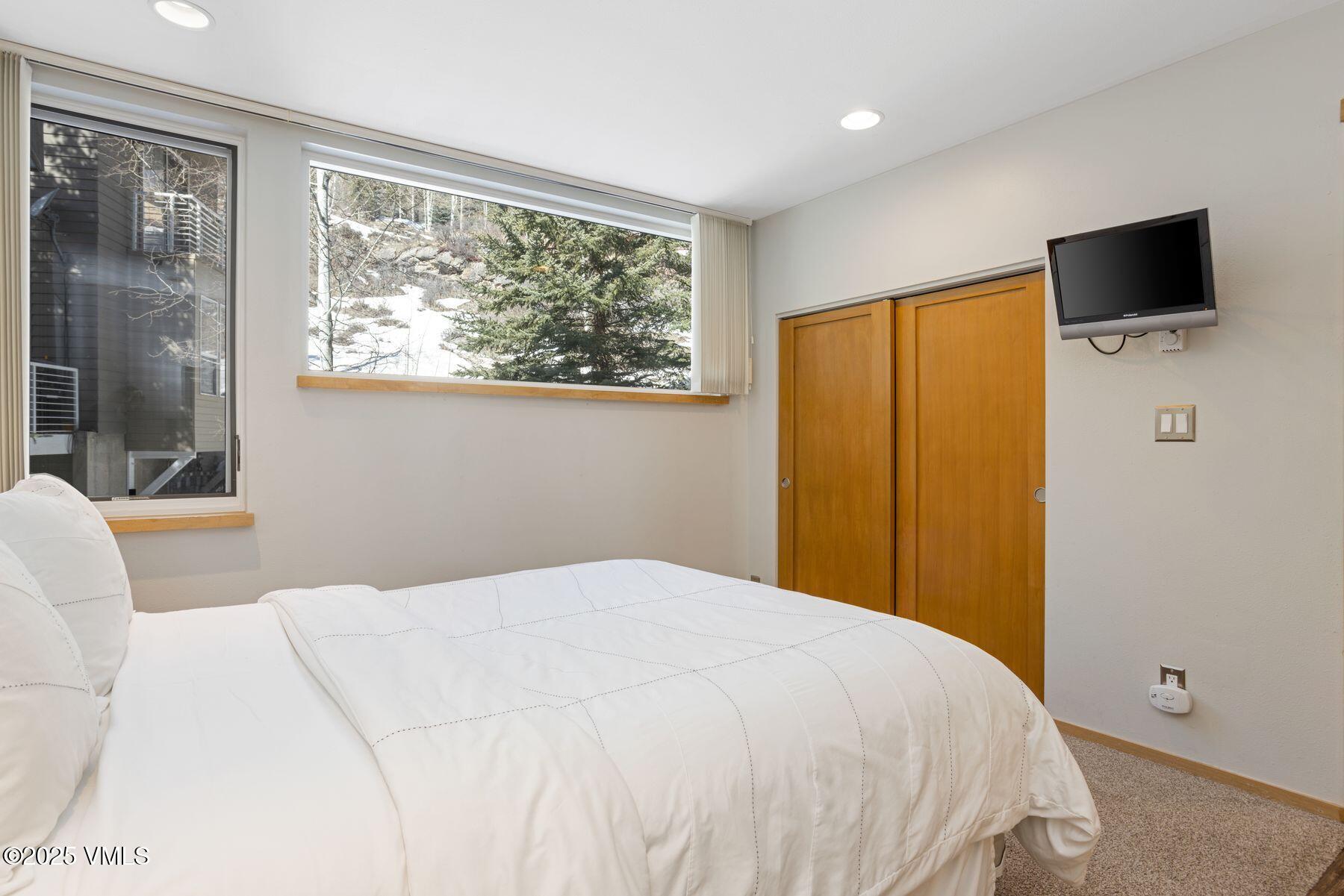 1100 North Frontage Road West, Unit 2311 Vail, CO 81657 - Photo 16 of 34 a bedroom with a bed and a flat screen tv
