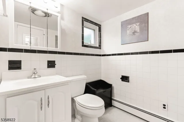 a bathroom with a sink a toilet and a mirror