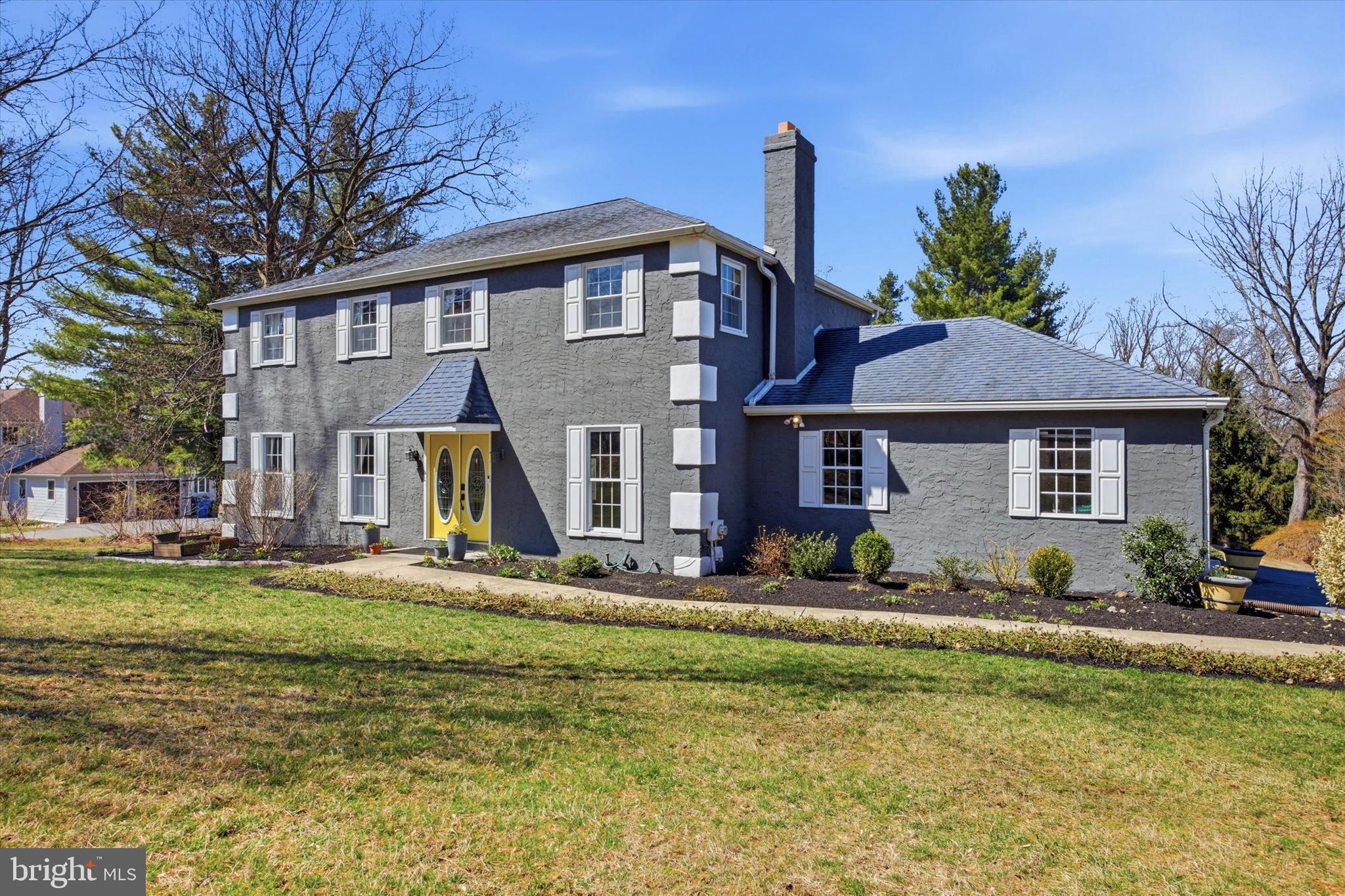 1 Country Village Way Media, PA 19063 - Photo 2 of 50 a front view of a house with a garden and trees