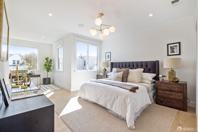 a bedroom with a large bed and a chandelier