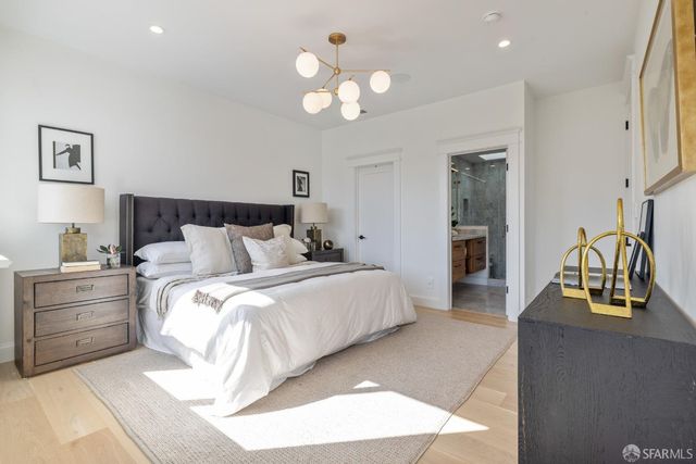 a spacious bedroom with a bed and a chandelier