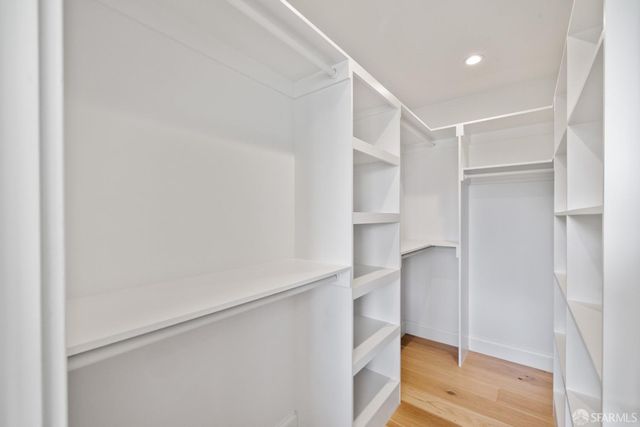 a view of walk in closet with wooden floor