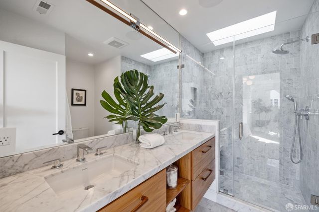 a bathroom with a granite countertop sink a shower and a mirror