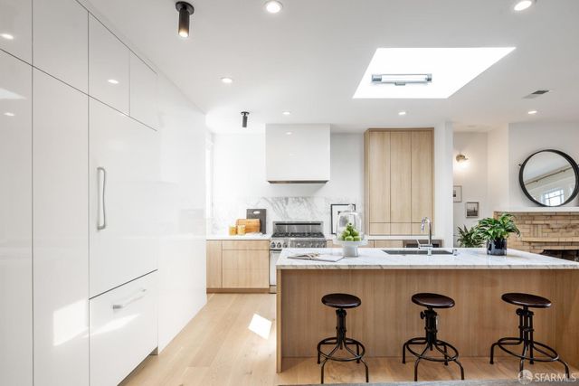 a kitchen with granite countertop a sink cabinets and stainless steel appliances