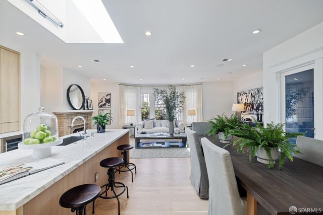 a living room with furniture potted plant and a large window
