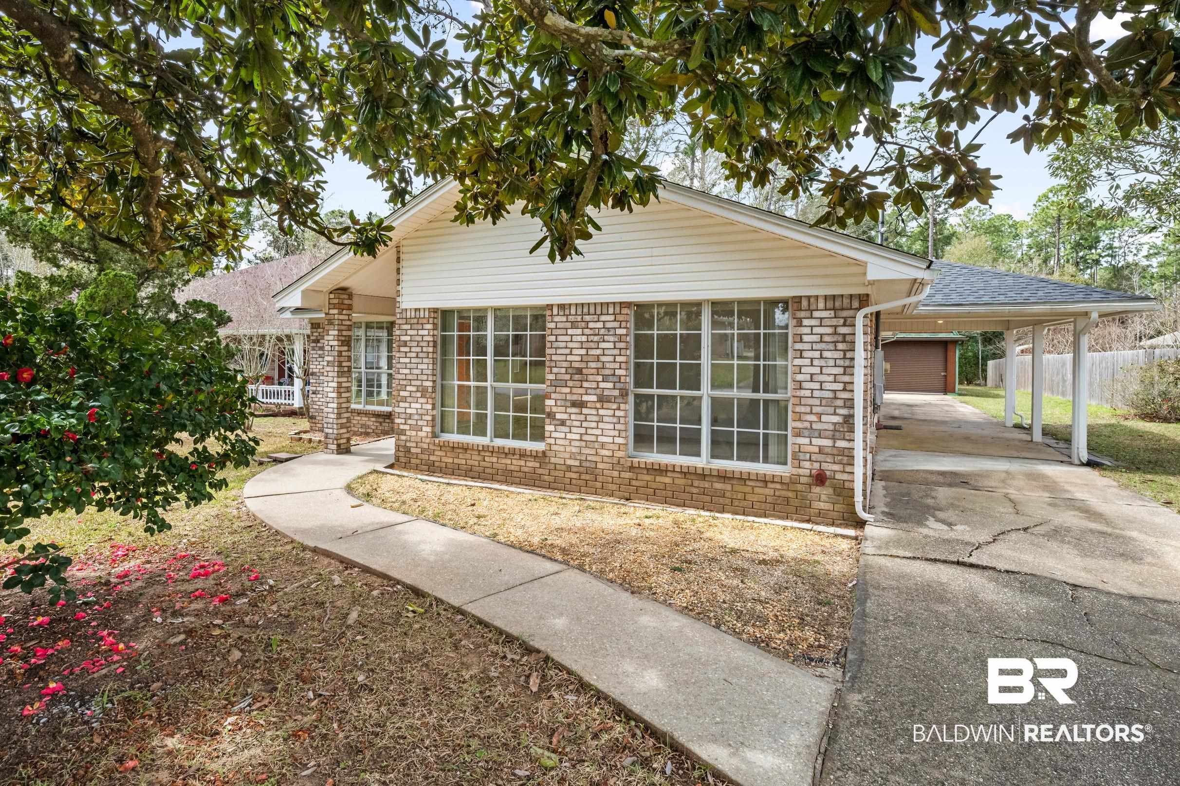 2673 Pine Ridge Drive Lillian, AL 36549 - Photo 1 of 38 View of front of property featuring driveway, brick siding, a carport, and fence